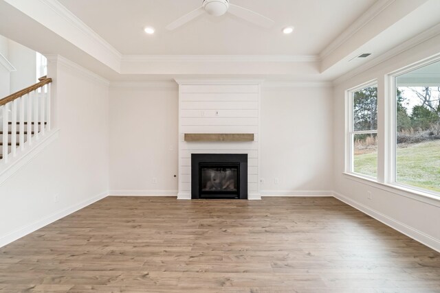 7317 Katherine Ct, Fairview, TN 37062 - unfurnished living room with a raised ceiling, wood finished floors, a large fireplace, stairs, and ceiling fan