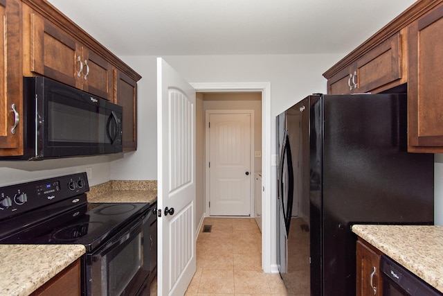 552 Magnolia Dr, Clarksville, TN 37042 - kitchen featuring black appliances, light tile patterned floors, and baseboards