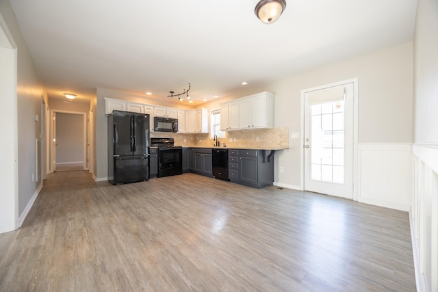 1905 Bugle Ct, Spring Hill, TN 37174 - kitchen featuring black appliances, light wood-type flooring, white cabinetry, and decorative backsplash