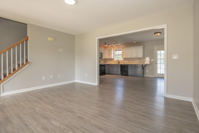1905 Bugle Ct, Spring Hill, TN 37174 - unfurnished living room featuring dark wood-style flooring, stairs, plenty of natural light, and track lighting