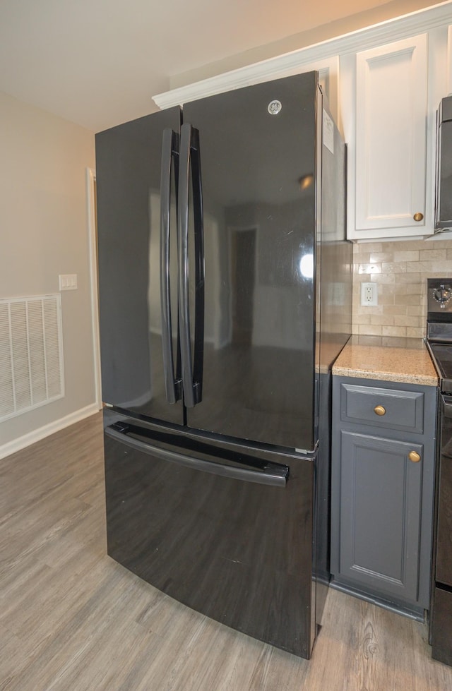 1905 Bugle Ct, Spring Hill, TN 37174 - kitchen featuring black appliances, light wood-style flooring, white cabinets, and backsplash