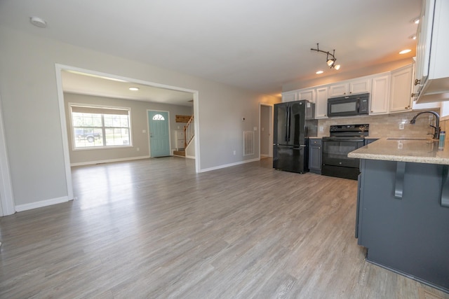 1905 Bugle Ct, Spring Hill, TN 37174 - kitchen featuring black appliances, tasteful backsplash, white cabinetry, open floor plan, and light wood finished floors