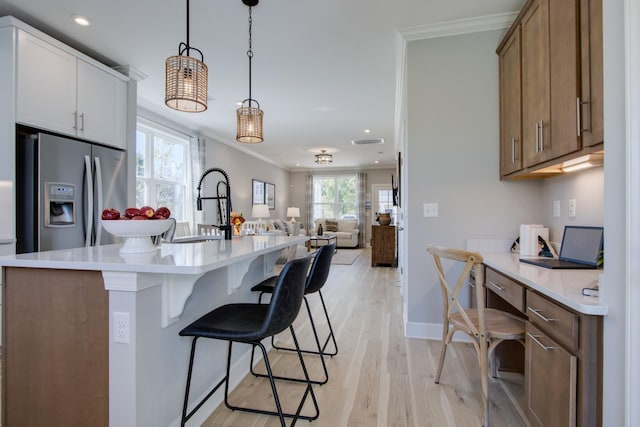 5220 Gladecress Ln NE, Hermitage, TN 37076 - kitchen featuring stainless steel fridge, crown molding, open floor plan, a breakfast bar area, and light countertops
