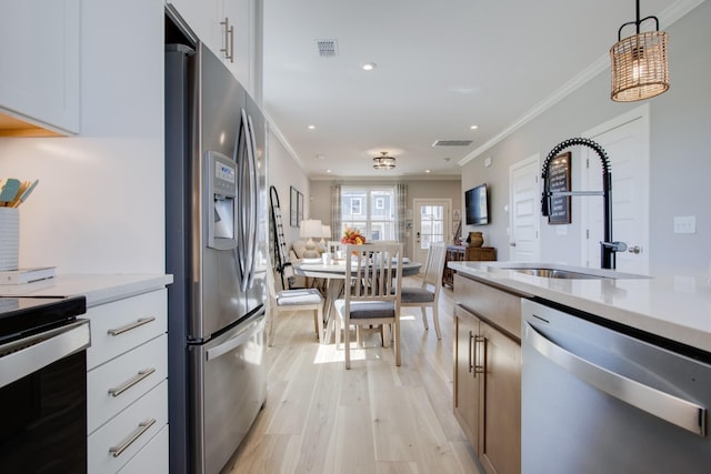 5220 Gladecress Ln NE, Hermitage, TN 37076 - kitchen with appliances with stainless steel finishes, a sink, light countertops, light wood-style floors, and crown molding
