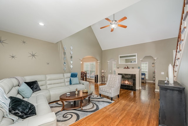 1245 Ben Hill Blvd, Nolensville, TN 37135 - living area featuring arched walkways, a ceiling fan, high vaulted ceiling, wood finished floors, and a tile fireplace