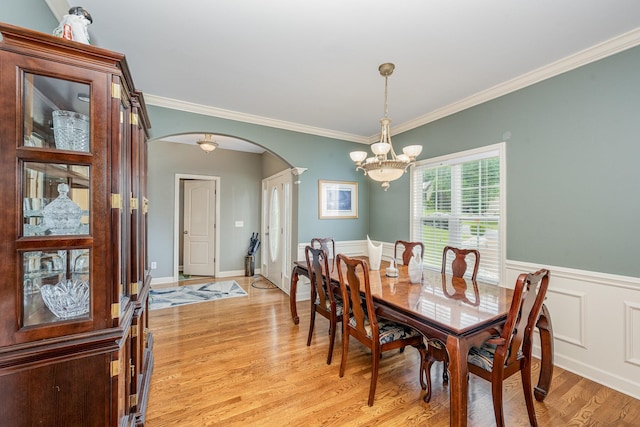 1245 Ben Hill Blvd, Nolensville, TN 37135 - dining space featuring arched walkways, a chandelier, light wood-style floors, crown molding, and wainscoting