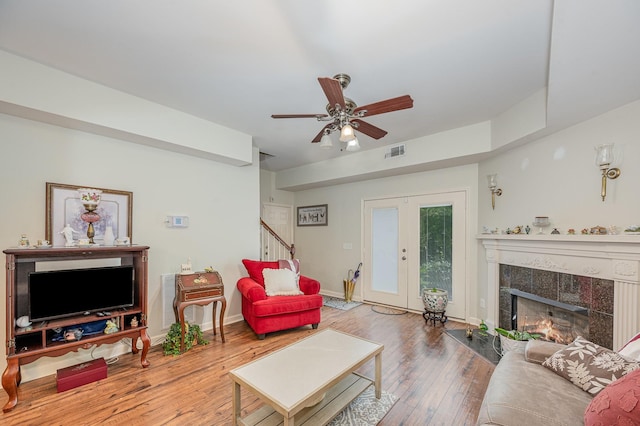 1245 Ben Hill Blvd, Nolensville, TN 37135 - living room with stairway, a tiled fireplace, wood-type flooring, a ceiling fan, and baseboards