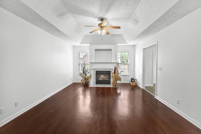 929 Chaparral Dr, Lebanon, TN 37087 - unfurnished living room with a tray ceiling, a ceiling fan, wood finished floors, a fireplace with flush hearth, and a textured ceiling