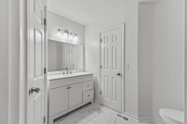 929 Chaparral Dr, Lebanon, TN 37087 - bathroom featuring toilet, vanity, marble look tile flooring, a textured ceiling, and baseboards