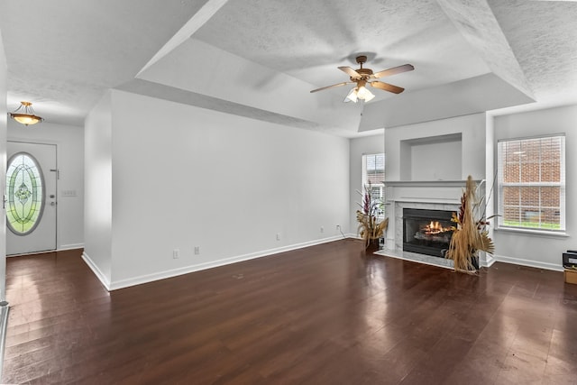 929 Chaparral Dr, Lebanon, TN 37087 - unfurnished living room featuring a textured ceiling, a tray ceiling, baseboards, ceiling fan, and a fireplace