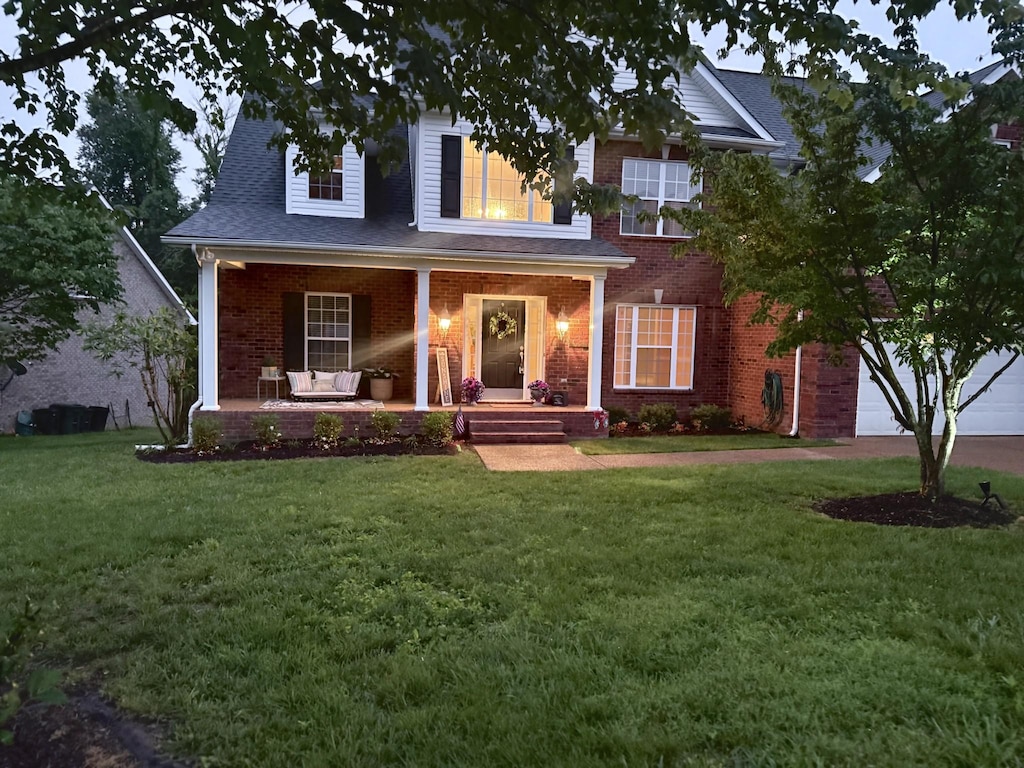146 Fieldcrest Cir, Hendersonville, TN 37075 - view of front of property featuring covered porch, brick siding, a front lawn, a garage, and roof with shingles