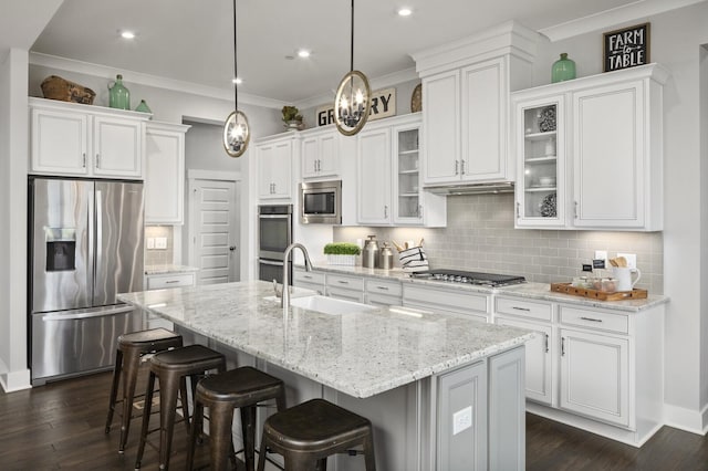 7890 Lampley Rd, Primm Springs, TN 38476 - kitchen featuring appliances with stainless steel finishes, a sink, white cabinets, a breakfast bar, and glass insert cabinets