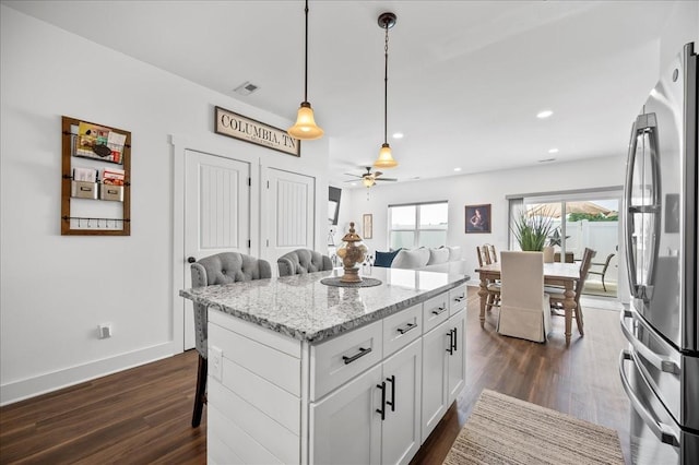 2183 Nectar Ln, Columbia, TN 38401 - kitchen with freestanding refrigerator, a breakfast bar area, dark wood-type flooring, white cabinets, and ceiling fan