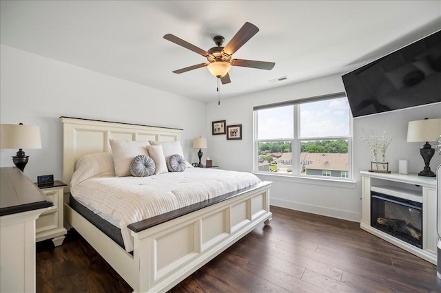 2183 Nectar Ln, Columbia, TN 38401 - bedroom featuring baseboards, dark wood-style floors, a ceiling fan, and a glass covered fireplace