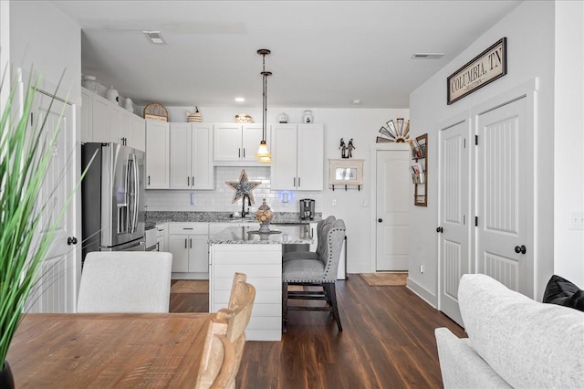 2183 Nectar Ln, Columbia, TN 38401 - kitchen with stainless steel fridge, backsplash, a kitchen breakfast bar, a kitchen island, and dark wood-type flooring