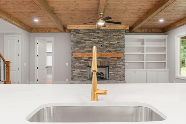 333 Burris Rd, Mount Juliet, TN 37122 - kitchen view of wooden ceiling with exposed beams, a ceiling fan, a sink, a stone fireplace, and recessed lighting