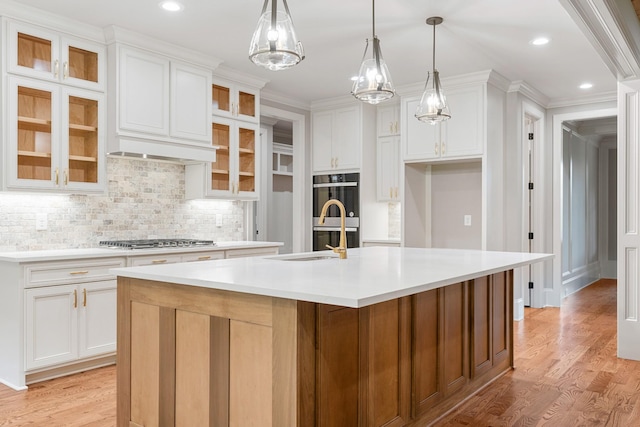 333 Burris Rd, Mount Juliet, TN 37122 - kitchen with appliances with stainless steel finishes, a sink, backsplash, a kitchen island with sink, and light wood-style floors