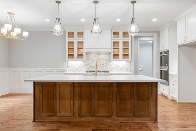 333 Burris Rd, Mount Juliet, TN 37122 - kitchen featuring stainless steel double oven, light countertops, a kitchen island with sink, tasteful backsplash, and crown molding
