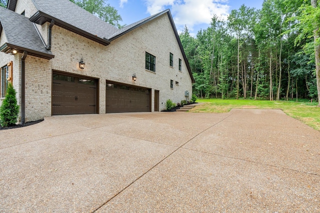 333 Burris Rd, Mount Juliet, TN 37122 - view of side of property featuring concrete driveway, brick siding, and roof with shingles