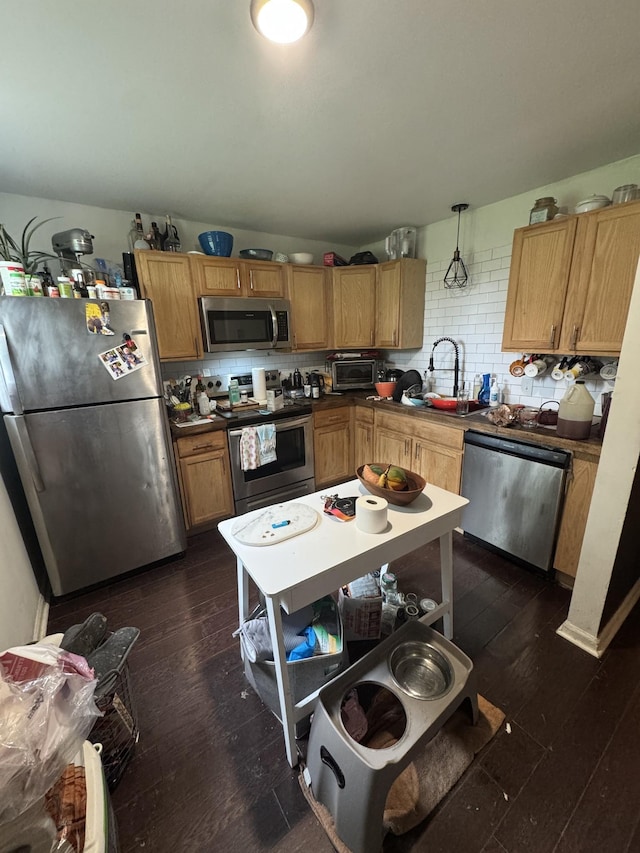 2408 Woodale Ln, Nashville, TN 37207 - kitchen featuring stainless steel appliances, dark wood-style floors, tasteful backsplash, a sink, and dark countertops