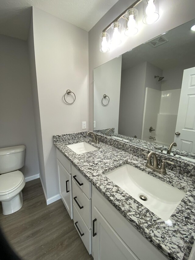 100 Wt Hardison Ave, Portland, TN 37148 - full bathroom featuring toilet, wood finished floors, baseboards, double vanity, and a shower
