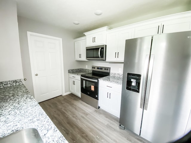 100 Wt Hardison Ave, Portland, TN 37148 - kitchen with stainless steel appliances, wood finished floors, white cabinetry, and light stone countertops