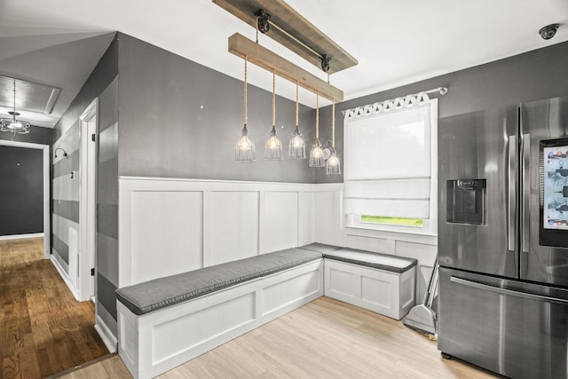 225 Nelson Dr, La Vergne, TN 37086 - kitchen with stainless steel fridge with ice dispenser, light wood-style floors, dark countertops, a wainscoted wall, and a decorative wall
