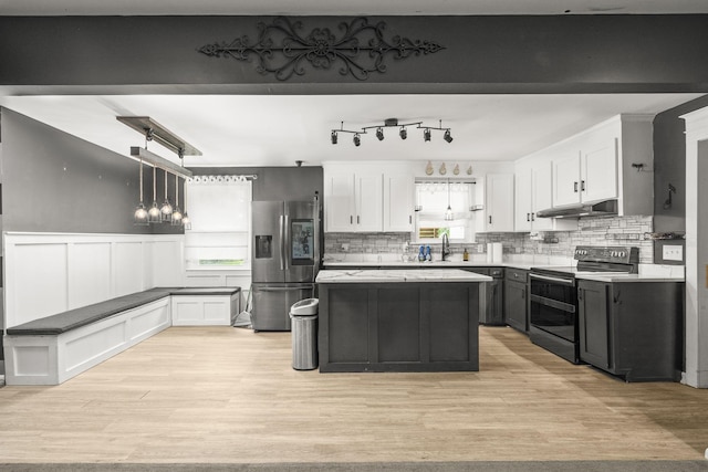 225 Nelson Dr, La Vergne, TN 37086 - kitchen with stainless steel fridge with ice dispenser, double oven range, under cabinet range hood, light wood-style flooring, and a wainscoted wall