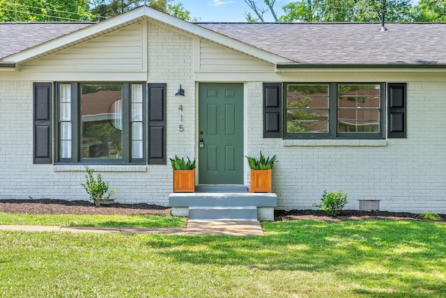 415 Jordan Rd, Clarksville, TN 37042 - view of exterior entry with brick siding, a yard, and a shingled roof