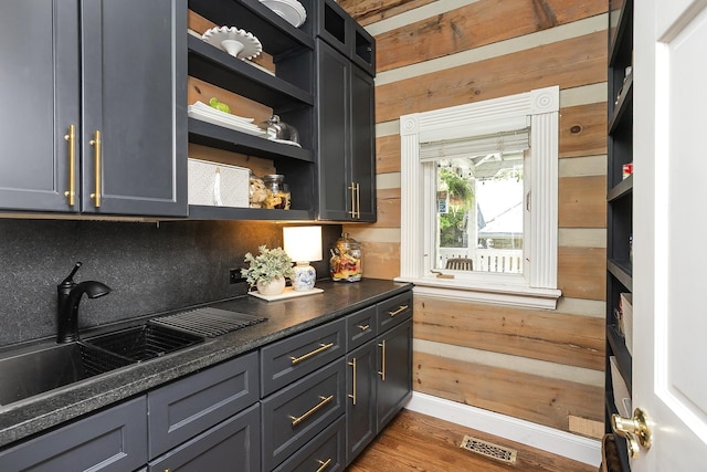 1105 Mount Pleasant Rd, Kingston Springs, TN 37082 - kitchen with open shelves, a sink, dark countertops, wood finished floors, and wooden walls