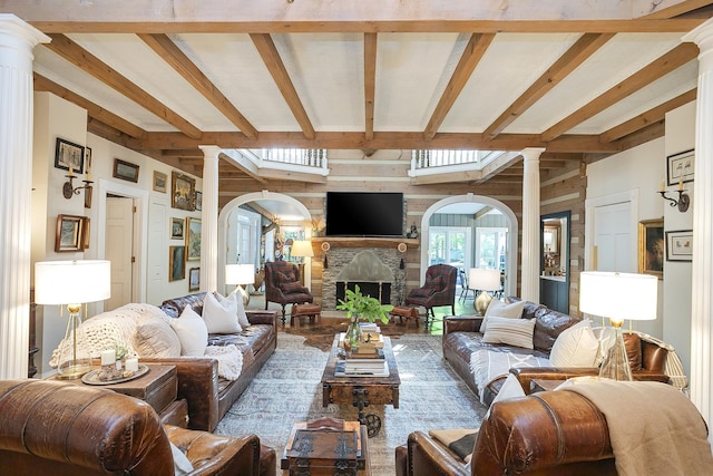 1105 Mount Pleasant Rd, Kingston Springs, TN 37082 - living room featuring decorative columns, beam ceiling, a large fireplace, arched walkways, and wood walls