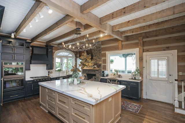 1105 Mount Pleasant Rd, Kingston Springs, TN 37082 - kitchen with ventilation hood, dark wood finished floors, double oven, a center island, and light stone countertops