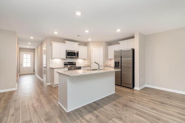 142 Rising Pvt Ln, Gallatin, TN 37066 - kitchen with stainless steel appliances, a sink, light wood-style flooring, baseboards, and a center island with sink