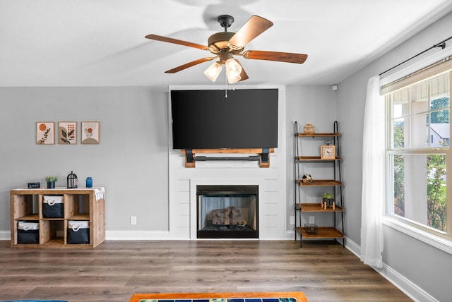 1341 Sussex Dr, Clarksville, TN 37042 - living area featuring a glass covered fireplace, a ceiling fan, wood finished floors, and baseboards