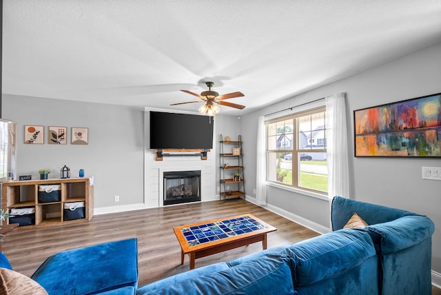 1341 Sussex Dr, Clarksville, TN 37042 - living area with wood finished floors, a ceiling fan, a large fireplace, and baseboards