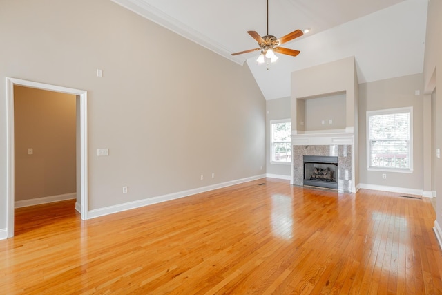 4370 Wellesley Dr, Ooltewah, TN 37363 - unfurnished living room featuring high vaulted ceiling, ceiling fan, light wood-type flooring, a tile fireplace, and baseboards