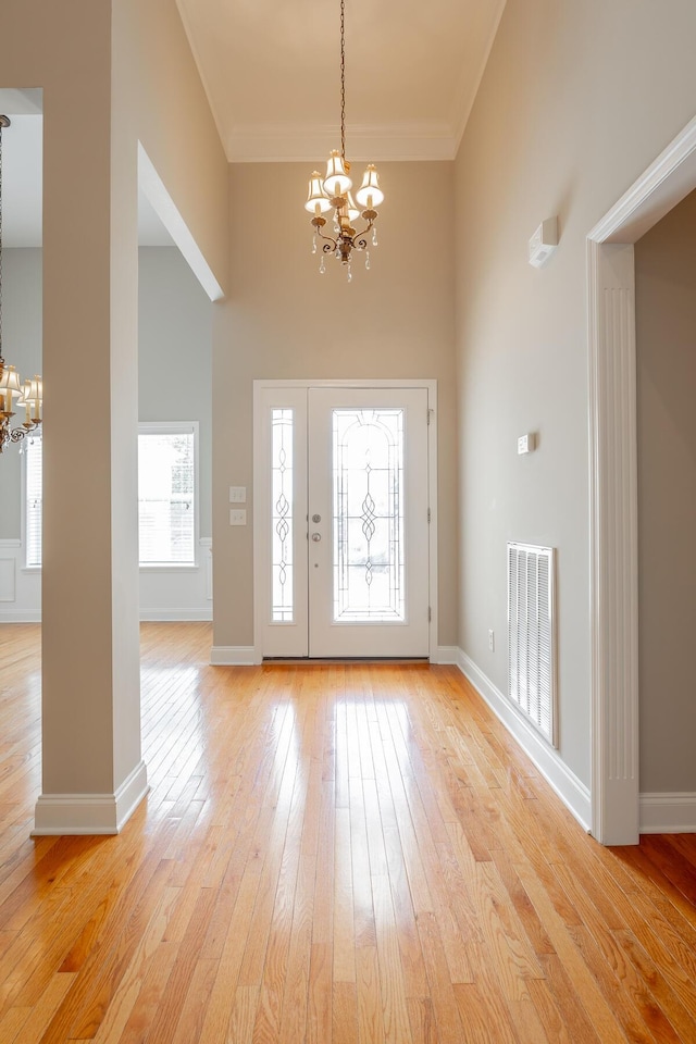 4370 Wellesley Dr, Ooltewah, TN 37363 - foyer with a chandelier, a towering ceiling, light wood-style flooring, crown molding, and baseboards
