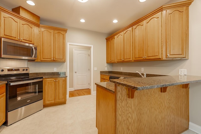 4370 Wellesley Dr, Ooltewah, TN 37363 - kitchen featuring stainless steel appliances, a breakfast bar area, a peninsula, baseboards, and recessed lighting