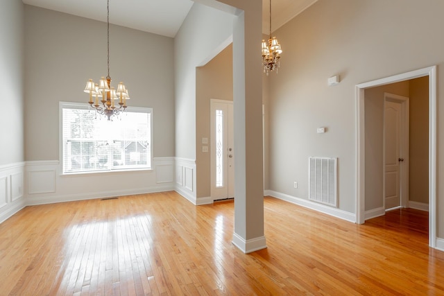 4370 Wellesley Dr, Ooltewah, TN 37363 - foyer featuring a chandelier, high vaulted ceiling, light wood finished floors, and wainscoting