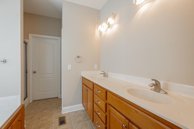 4370 Wellesley Dr, Ooltewah, TN 37363 - full bath featuring double vanity, a stall shower, tile patterned flooring, and baseboards