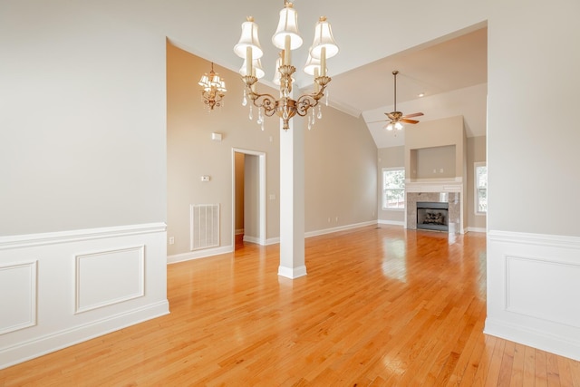 4370 Wellesley Dr, Ooltewah, TN 37363 - unfurnished living room featuring a ceiling fan, a tiled fireplace, light wood-style floors, high vaulted ceiling, and a chandelier