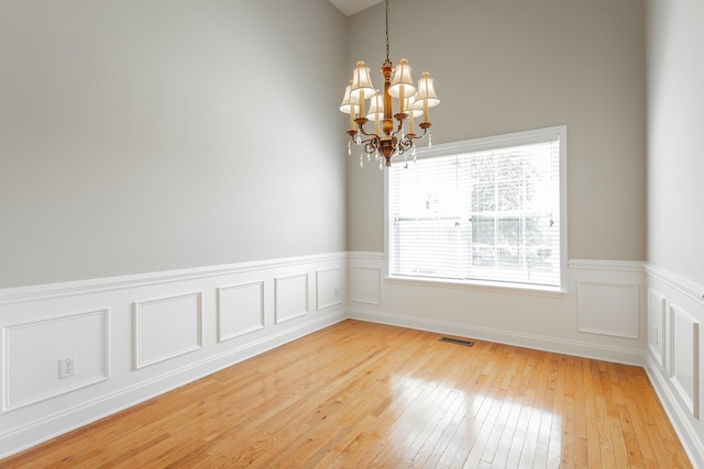 4370 Wellesley Dr, Ooltewah, TN 37363 - spare room with a chandelier, light wood-style flooring, a wainscoted wall, and a decorative wall