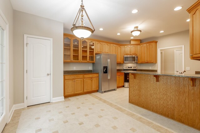 4370 Wellesley Dr, Ooltewah, TN 37363 - kitchen with stainless steel appliances, a breakfast bar, glass insert cabinets, recessed lighting, and a peninsula