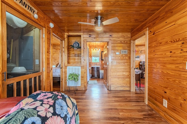 230 Silver Water Ln, Counce, TN 38326 - bedroom featuring electric panel, wood walls, wood finished floors, wood ceiling, and connected bathroom