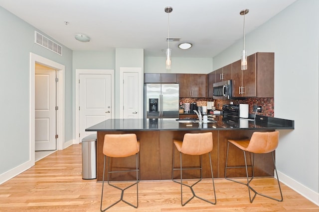 817 3rd Ave N Unit 411, Nashville, TN 37201 - kitchen with stainless steel appliances, a peninsula, a sink, decorative backsplash, and baseboards