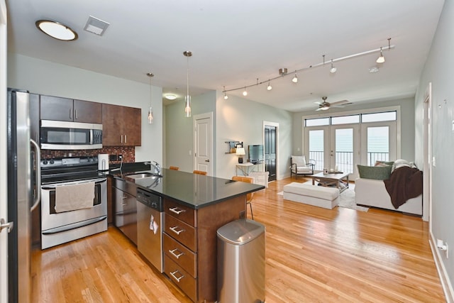 817 3rd Ave N Unit 411, Nashville, TN 37201 - kitchen with appliances with stainless steel finishes, a peninsula, light wood-style flooring, and dark countertops