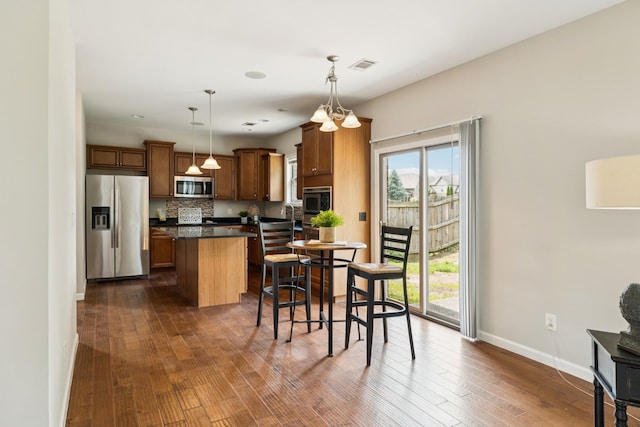 2040 Belshire Way, Spring Hill, TN 37174 - kitchen featuring stainless steel appliances, dark countertops, baseboards, a center island, and dark wood finished floors
