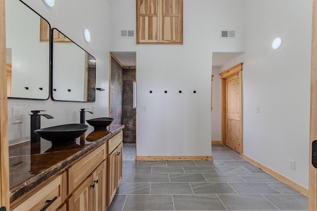 619 Bridgeview Cv, Bath Springs, TN 38311 - full bathroom featuring a high ceiling, double vanity, walk in shower, and baseboards