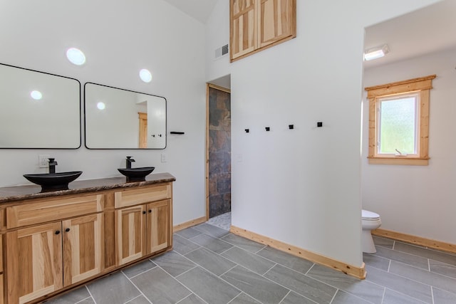 619 Bridgeview Cv, Bath Springs, TN 38311 - full bath featuring double vanity, walk in shower, baseboards, toilet, and a towering ceiling