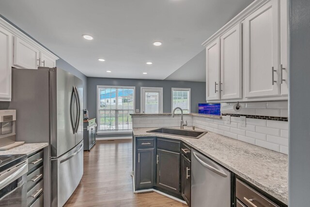 1305 Standing Stone Cir, Columbia, TN 38401 - kitchen with a sink, appliances with stainless steel finishes, light wood-type flooring, backsplash, and white cabinets